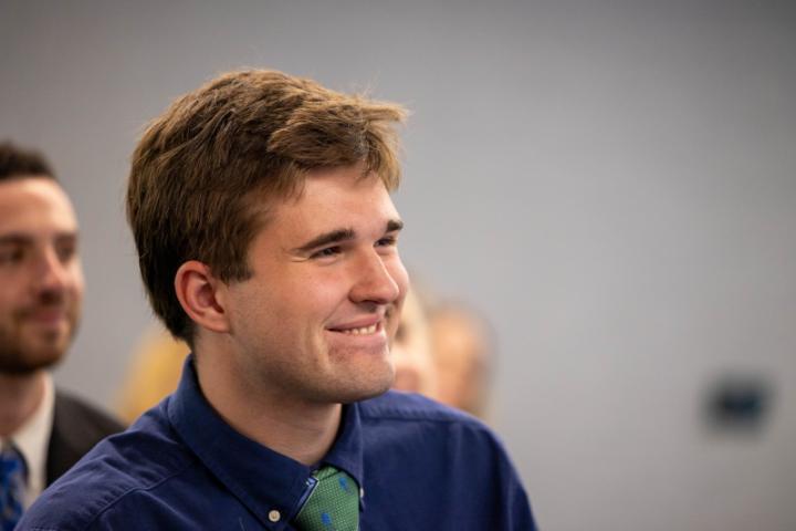 A student smiles while listening to the panel