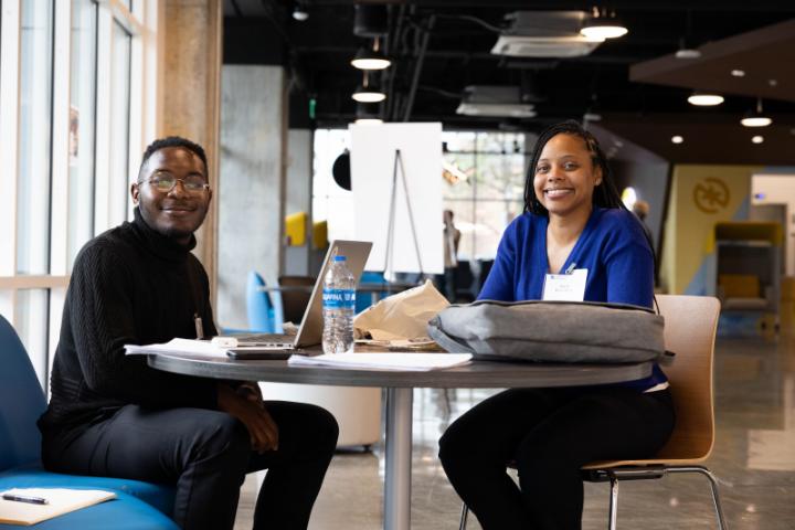 Two students pose and smile for a photo